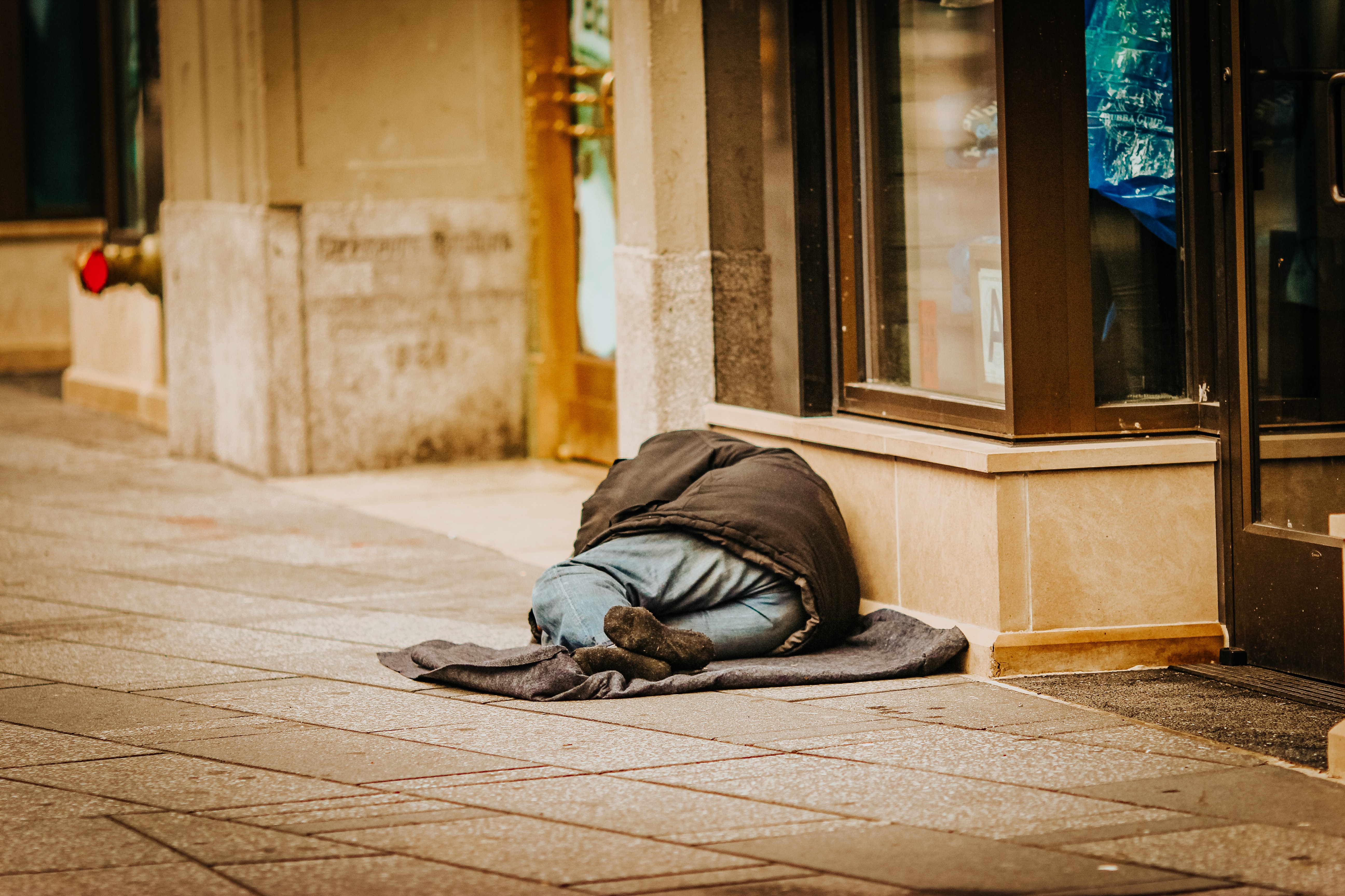 person in coat lying on street floor